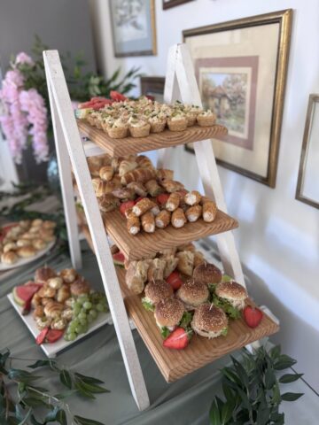Pecivo, mini sendiviči i slane korpice poređane na daske i dekorisane jagodama