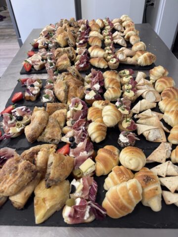 pecivo i kanapei na crnim daskama, dekorisan ketering za svaku priliku